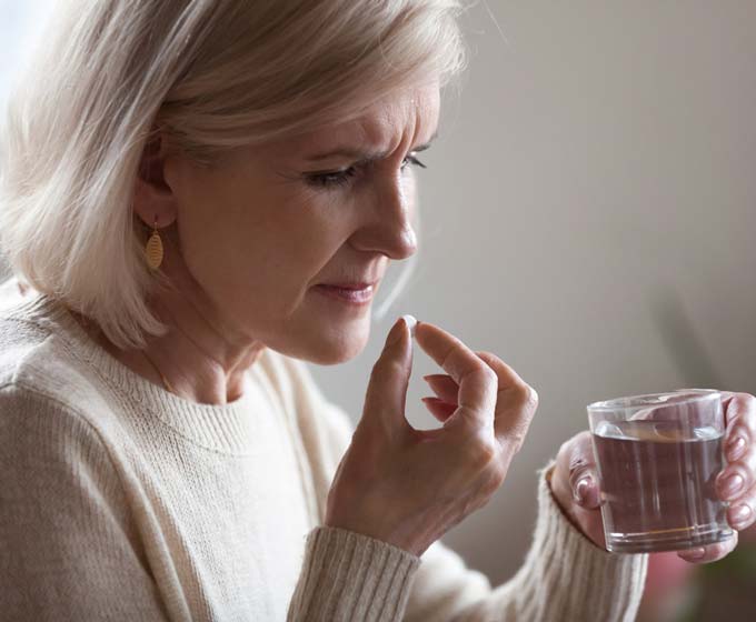 Frau Tabletten Medikament Psychose Wasserglas