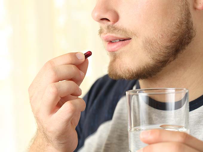 Einnahme Medikamente Mann Kapsel Wasserglas